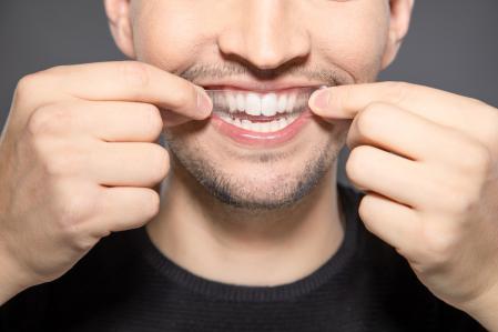 Man using a dental whitening product.