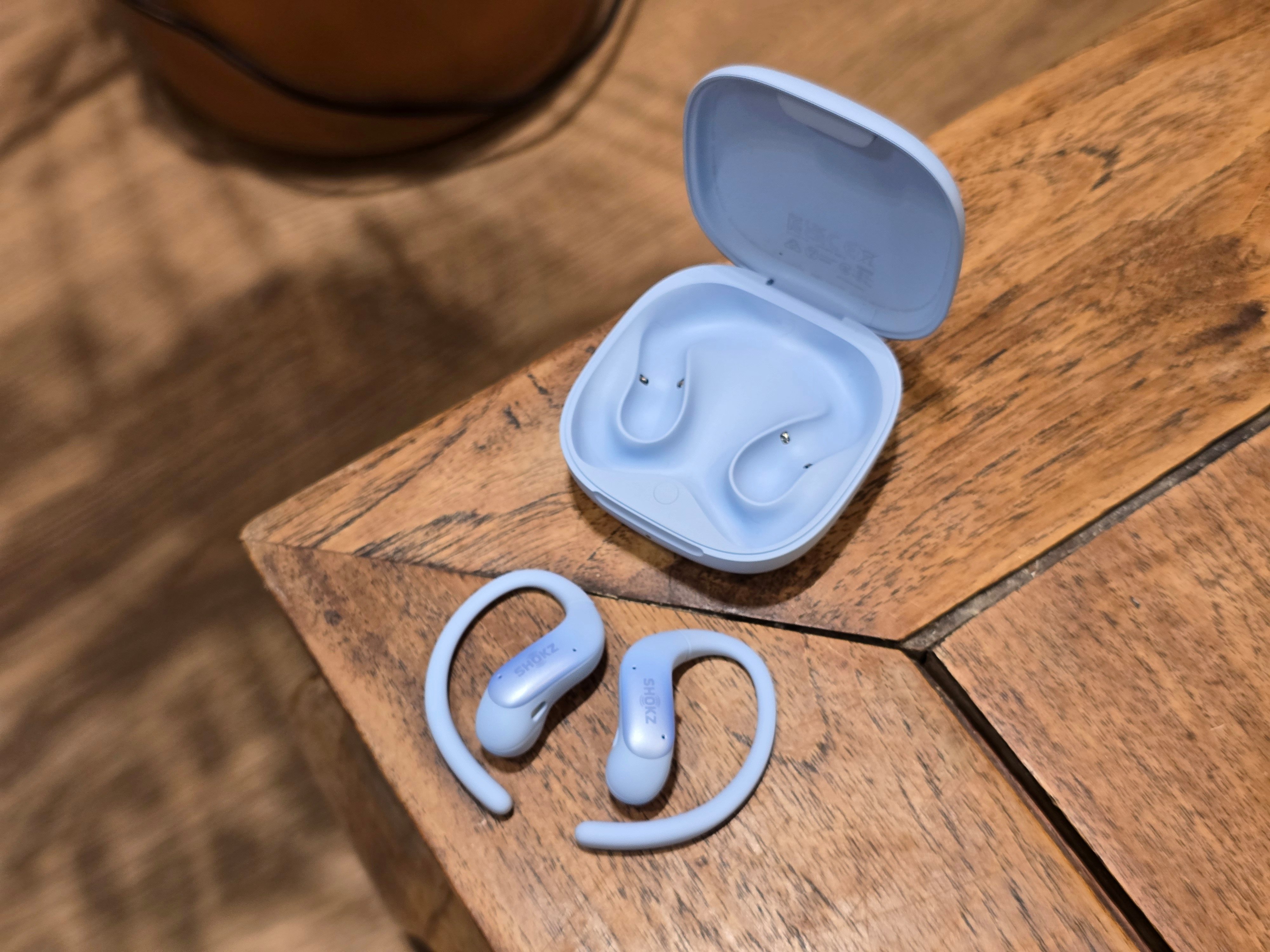 Les OpenFit Air 2 accompagnés de leur boîtier de charge, lui aussi certifié contre les projections d’eau et la poussière. © Matthieu Legouge