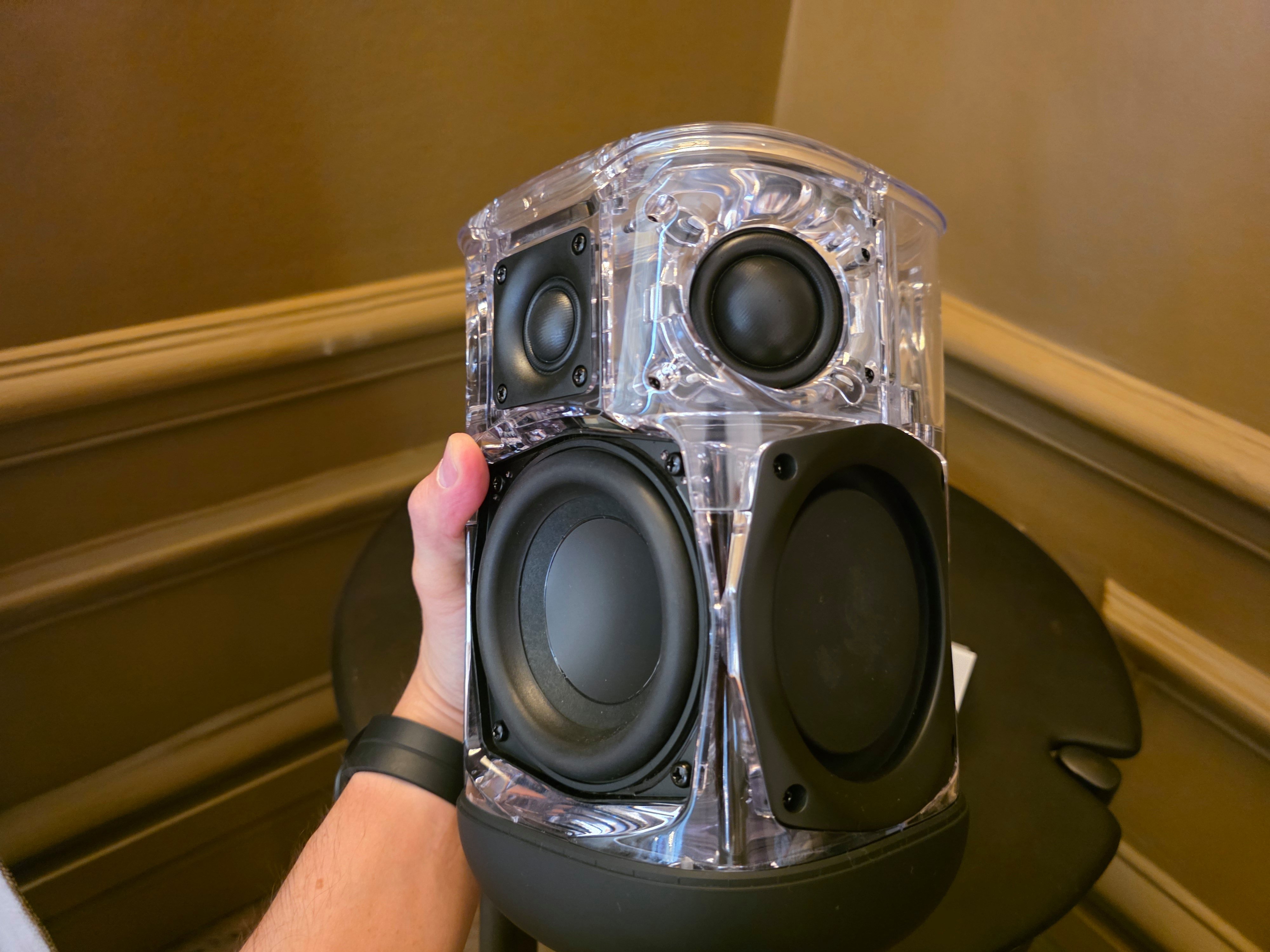 Architecture de la JBL Cove P1 (ici dans une version acrylique). Nous pouvons distinguer le woofer de 105 mm (à gauche), un des deux radiateurs passifs, le petit tweeter frontal de 20 mm, et l'un des tweeters de 30 mm © Guillaume Fourcadier pour Clubic